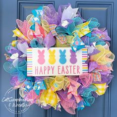 a colorful easter wreath on a blue door with the words happy easter written on it