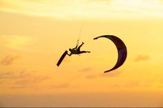 a person is parasailing in the ocean at sunset