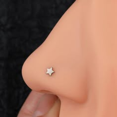 a close up of a person's nose with a small silver star on it