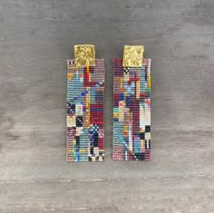 two pairs of colorful beaded earrings on top of a wooden table next to each other