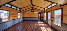 an empty room with wood floors and windows