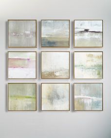 six abstract paintings hang on the wall above a chair in front of a white couch