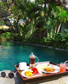 a tray with food on it next to a pool