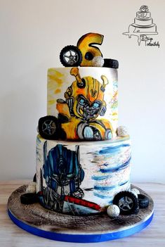 a three tiered cake with an image of a robot on it's side