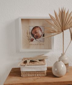 a wooden table topped with two vases filled with flowers and a baby's head