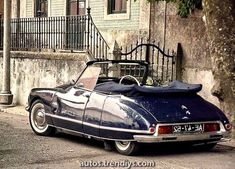 an old car is parked on the side of the road in front of a building