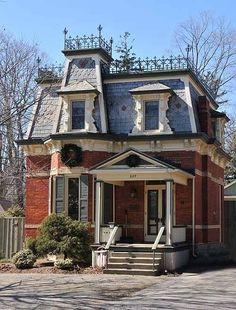 an old brick house with a clock on the top of it's steeple