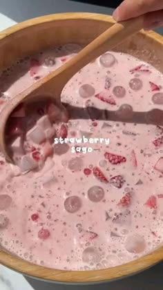 a wooden bowl filled with ice cream and strawberries