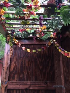 a wooden structure with flowers and leaves hanging from it