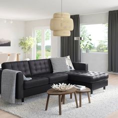 a living room filled with furniture and a white rug on the floor in front of a window