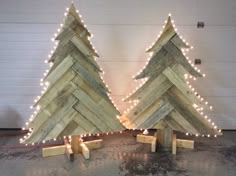 two wooden christmas trees with lights on them