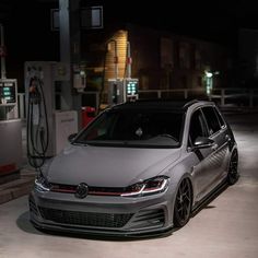 a grey volkswagen car parked at a gas station