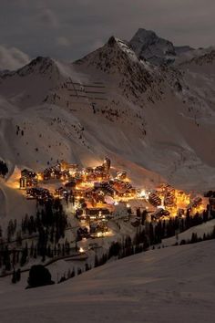 a ski resort lit up at night in the mountains