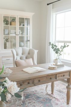 a living room with white furniture and flowers in vases on the coffee table next to it