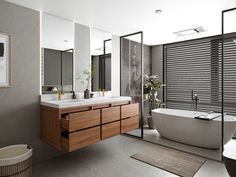 a bathroom with a bathtub, sink and large mirror on the wall next to it