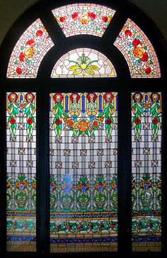 an ornate stained glass window with flowers on it