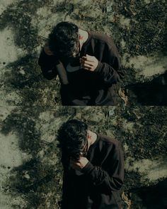 a man standing in front of a stone wall holding his hands to his face and looking down