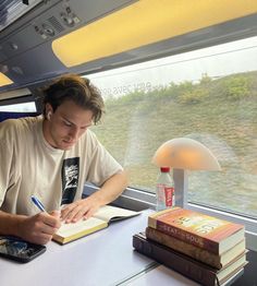 a man sitting at a table writing on a book