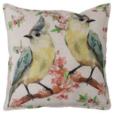 two birds sitting on top of a pillow