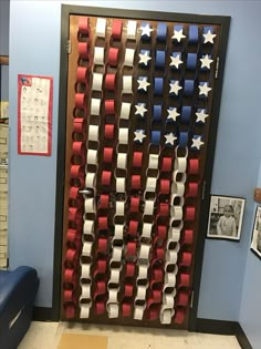 an american flag made out of red, white and blue chairs in front of a door