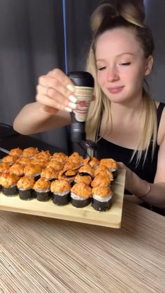 a woman is making cupcakes with an electric grinder