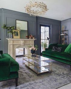 a living room filled with green couches and a fire place