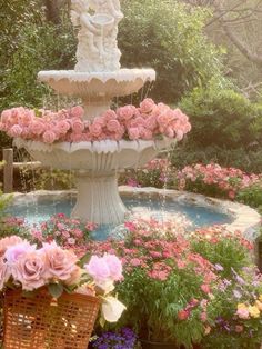 there is a fountain with pink flowers in the center and two baskets next to it