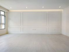 an empty room with white walls and wood floors