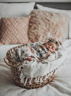 a baby in a basket on top of a bed