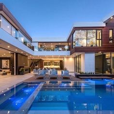 an indoor swimming pool in the middle of a large house with glass doors and windows