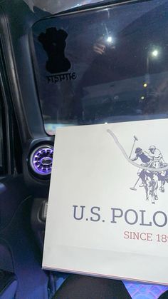 a us polo sign is on the dashboard of a car