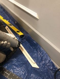 a pair of gloves is laying on the floor next to a ruler and measuring tape