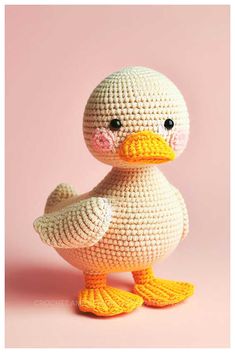 a crocheted duck sitting on top of a pink surface