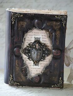 an old book with a cross on the cover and some words written in it, sitting on a table