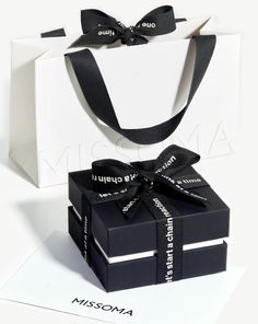 two black and white boxes with ribbons tied around them