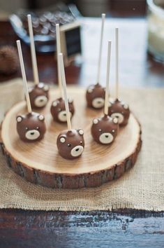 chocolate candies are arranged on a wooden plate with toothpicks in the shape of bears