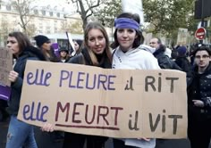 two girls holding a sign that says we pleur a rit que meurt livt