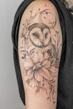 an owl and flower tattoo on the arm