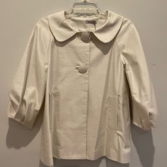 Beautiful Short Jacket, Cotton And Polyester, Bought In Paris In 2007, Never Worn. Front Pockets, Cool Pleating On 3/4 Sleeves. Perfect For Over An Evening Dress Or Bridal Gown. 2 Buttons, Tent Shape. Length From Neck, 22 1-2 Inches. Tag Still On Fitted Cream Collared Outerwear, Retro Cream Outerwear For Spring, Retro Beige Outerwear For Spring, Retro Beige Spring Outerwear, Vintage Winter Outerwear With Button Closure, Vintage Winter Outerwear With Double Button Closure, Vintage Oversized Outerwear With Button Closure, Vintage Fitted Outerwear With Button Closure, Vintage Cream Outerwear With Button Closure