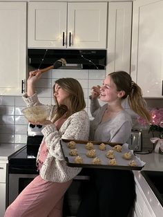 two women are baking cookies in the kitchen