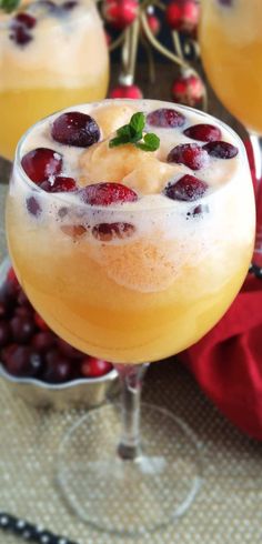 a close up of a drink in a glass with fruit on the rim and garnishes