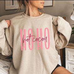 Stay cozy this holiday season with our "Ho Ho Hot Cocoa" sweater! Perfect for winter days, this fun and festive design celebrates the warmth and joy of hot cocoa and holiday cheer. Made from soft, comfortable fabric, it's ideal for lounging at home, holiday gatherings, or sipping your favorite winter treat by the fire. Whether you're treating yourself or gifting it to a loved one, this playful sweater is sure to bring some extra warmth and smiles to the season! Ideal for any situation, a unisex Cute Winter Sweatshirt With Letter Print, Cute Winter Sweater With Letter Print, Cozy Christmas Tops With Relaxed Fit, Cute Letter Print Winter Sweater, Cozy Crew Neck Top For Holidays, Cute Winter Holiday Tops, Cute Winter Sweater As A Gift, Cute Relaxed Fit Tops For Winter, Cozy Relaxed Fit Christmas Tops