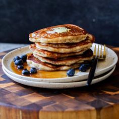 a stack of pancakes with syrup and blueberries on a plate