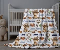 a baby crib with a teddy bear and name blanket