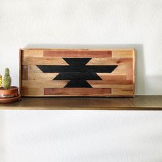 a wooden shelf topped with a potted cactus