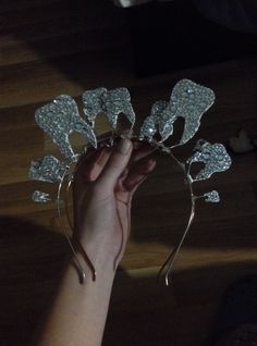 a person is holding a tiara in their hand