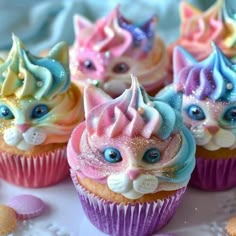 cupcakes with colorful frosting and cat faces on them