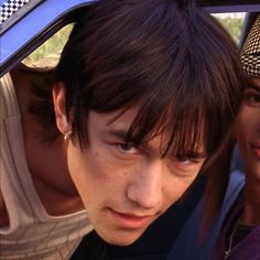 two young men looking out the window of a car