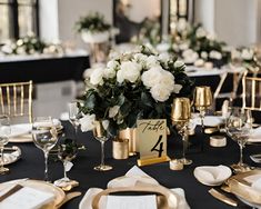 the table is set with gold and white flowers