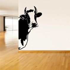 a black and white cow wall decal in an empty room with hardwood floors,